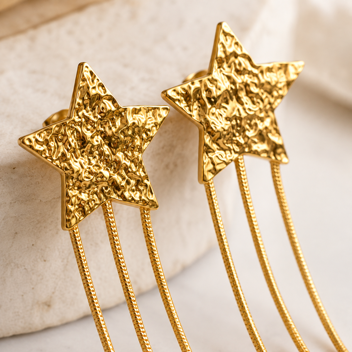 Detalle de pendientes de estrella dorados de acero inoxidable con tres cadenas Bonyk
